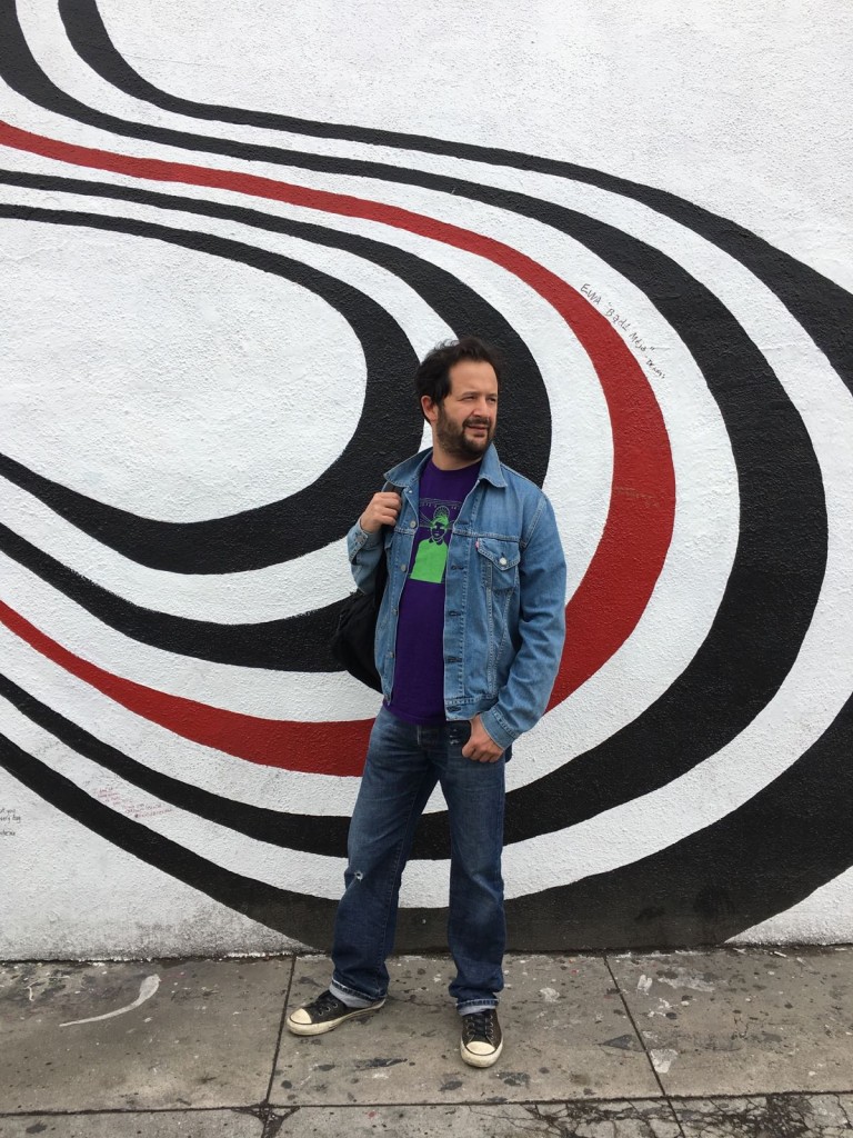 Marco in posa davanti al murales